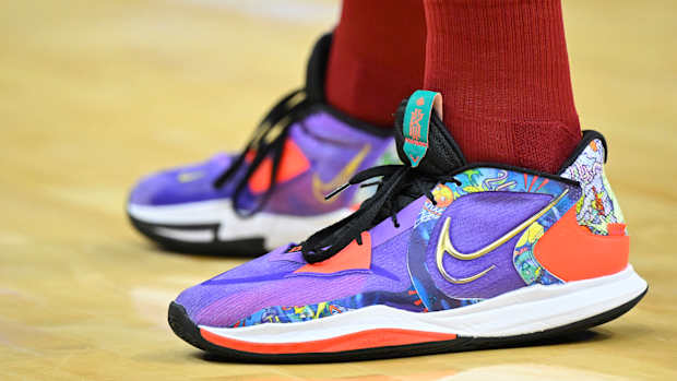 View of purple, black, and white Nike Kyrie shoes.